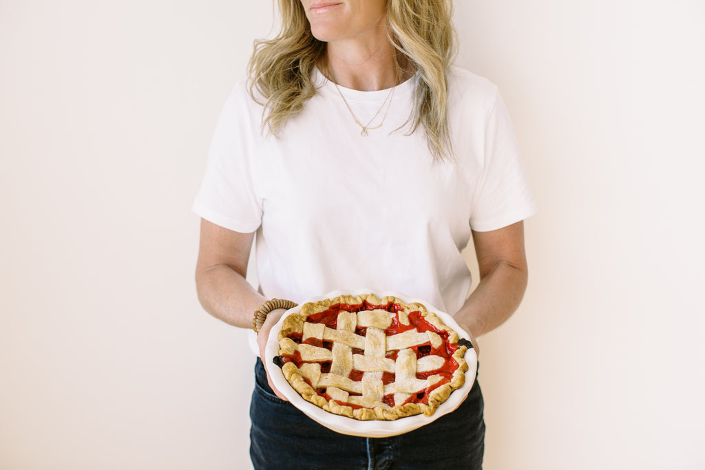 Person holding a strawberry rhubarb pie